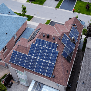 The rooftop of a house equipped with solar panels, showcasing a SolarUp technician engaged in the installation process.